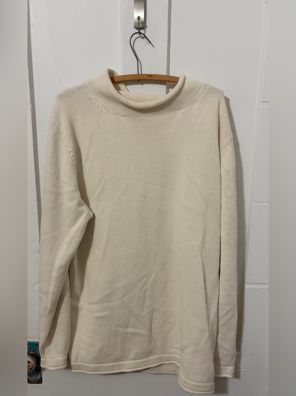 The Normal Brand classic cream-colored knit rollneck sweater.